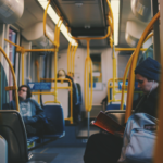 Interior of a bus with three people in it.